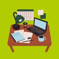 Ein Schreibtisch mit Laptop und Schreibmaterial auf grünem Hintergrund