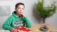 Abbildung von einem Jungen, der mit LÜK spielt