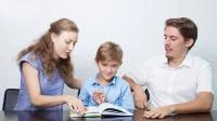 Eltern schauen sich mit ihrem Sohn ein Buch an