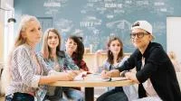 Jugendliche sitzen an einem Tisch in der Schule