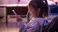 Ein Mädchen schaut auf sein Smartphone