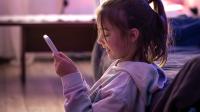 Ein Mädchen schaut auf sein Smartphone