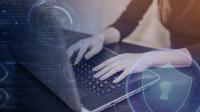 Hände an Laptop mit Bildelementen zur Datensicherheit.