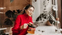 Eine Mutter nimmt sich eine kleine Auszeit in einem Café und trinkt Tee