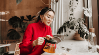 Eine Mutter nimmt sich eine kleine Auszeit in einem Café und trinkt Tee