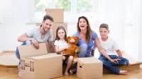 Foto einer Familie beim Umzug zwischen Kartons