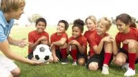 Foto einer Fußballgruppe mit jugendlichem Trainer