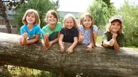 Gruppenfoto mit Kindern auf einem Baumstamm