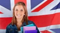 Schülerin mit Blöcken und Heften, vor dem Union-Jack