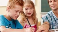 Zwei Kinder und Lehrer beim Schreiben