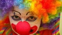 Eine als Clown geschminkte und verkleidete Person