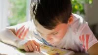 Foto eines Jungen beim konzentrierten Lesen