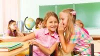 Mädchen flüstern im Klassenzimmer