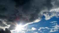Dramatische Wolkenformation mit Sonne und blauem Himmel