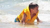 Junge mit Schwimmweste im Wasser