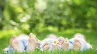 Eine Familie liegt im Gras