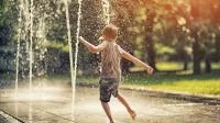 Foto eines spielenden Kindes im Springbrunnen