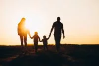 Familie spaziert im Sonnenuntergang