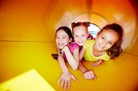 Kinder spielen in einer Röhrenrutsche