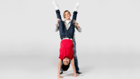 Ein Kind macht einen Handstand, während ein anderes Kind ihm dabei hilft