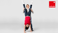 Ein Kind macht einen Handstand, während ein anderes Kind ihm dabei hilft