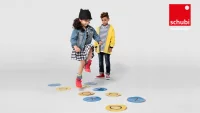 Zwei Kinder spielen ein Hüpfe-Kästchen-Spiel aus Kreisen