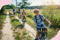 Kinder fahren mit ihren Fahrrädern über einen Feldweg in der Sonne