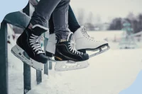 Foto von Beinen mit Schlittschuhen am Rand eines gefrorenen Sees