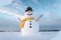Ein großer Schneemann steht in einer Winterlandschaft mit blauem Himmel