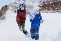 Zwei Kinder machen eine Schneeballschlacht im Winter