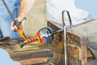 In einer Glashütte wird ein Gefäß aus buntem Glas gefertigt