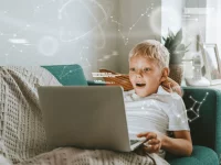 Ein Junge mit Laptop auf dem Schoß und digitalen Illustrationen um ihn herum