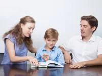 Eltern schauen sich mit ihrem Sohn ein Buch an