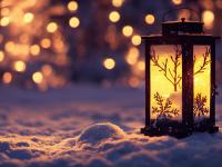 Foto einer kleinen weihnachtlich dekorierten Laterne, die im Schnee steht