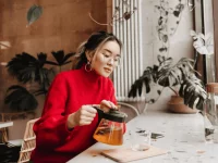 Eine Mutter nimmt sich eine kleine Auszeit in einem Café und trinkt Tee