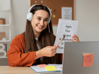 Ein Mädchen lernt Englisch-Vokabeln vor ihrem Laptop und trägt Kopfhörer