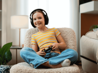 Mädchen spielt ein Videospiel und hält einen Controller in der Hand