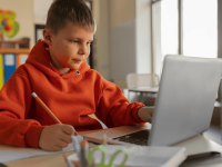 Ein Junge macht seine Hausaufgaben vor seinem Laptop