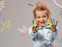 Ein Kind streckt seine bunt angemalten Hände in die Kamera und lacht