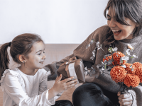 Ein Kind schenkt seiner Mutter ein Geschenk am Muttertag