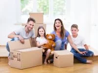 Foto einer Familie beim Umzug zwischen Kartons