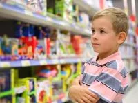 Junge steht vor Spielzeugregal im Shop