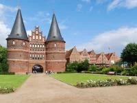 Foto einer Gebäudeanlage aus Backstein mit Türmen