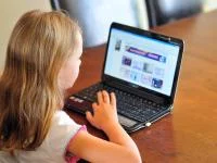 Kind beschäftigt sich am Laptop