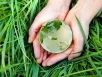 Kinderhände halten einen Glasmurmelglobus