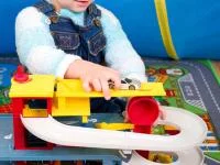 Kind spielt mit Spielzeug-Parkgarage