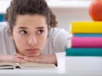 Jugendliche legt ihren Kopf auf den Tisch
