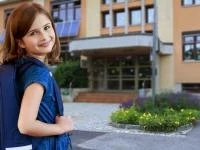 Lächelndes Mädchen vor der Schule