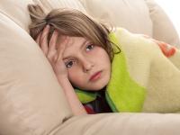 Kind liegt erschöpft unter einer Decke