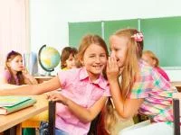 Mädchen flüstern im Klassenzimmer